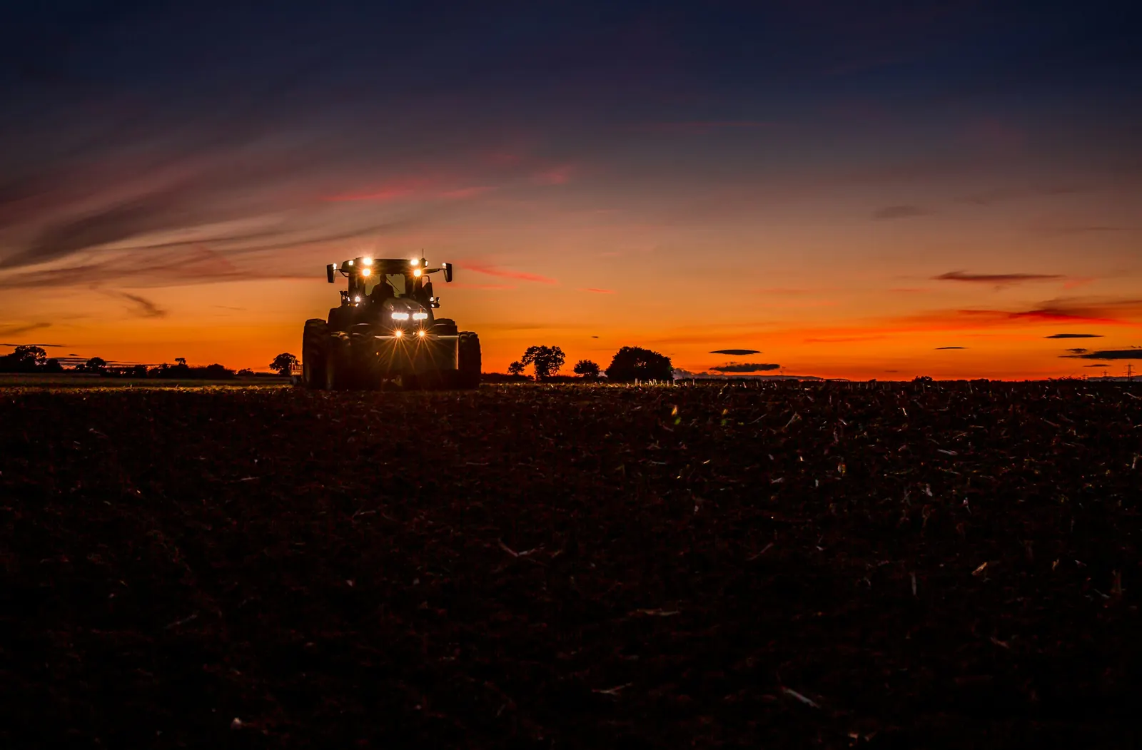 Trator em um campo ao pôr do sol