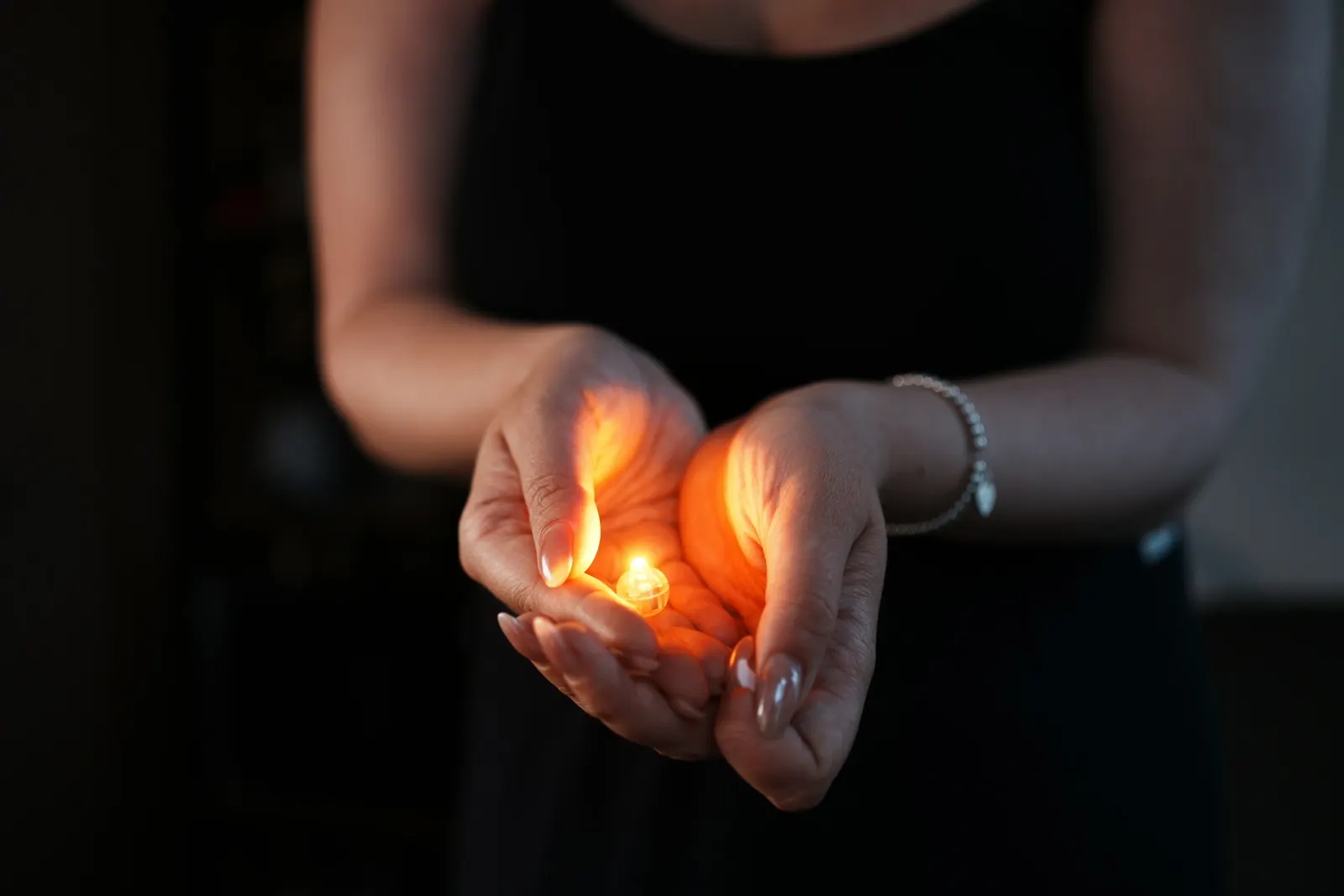 Mãos em concha segurando uma luz quente