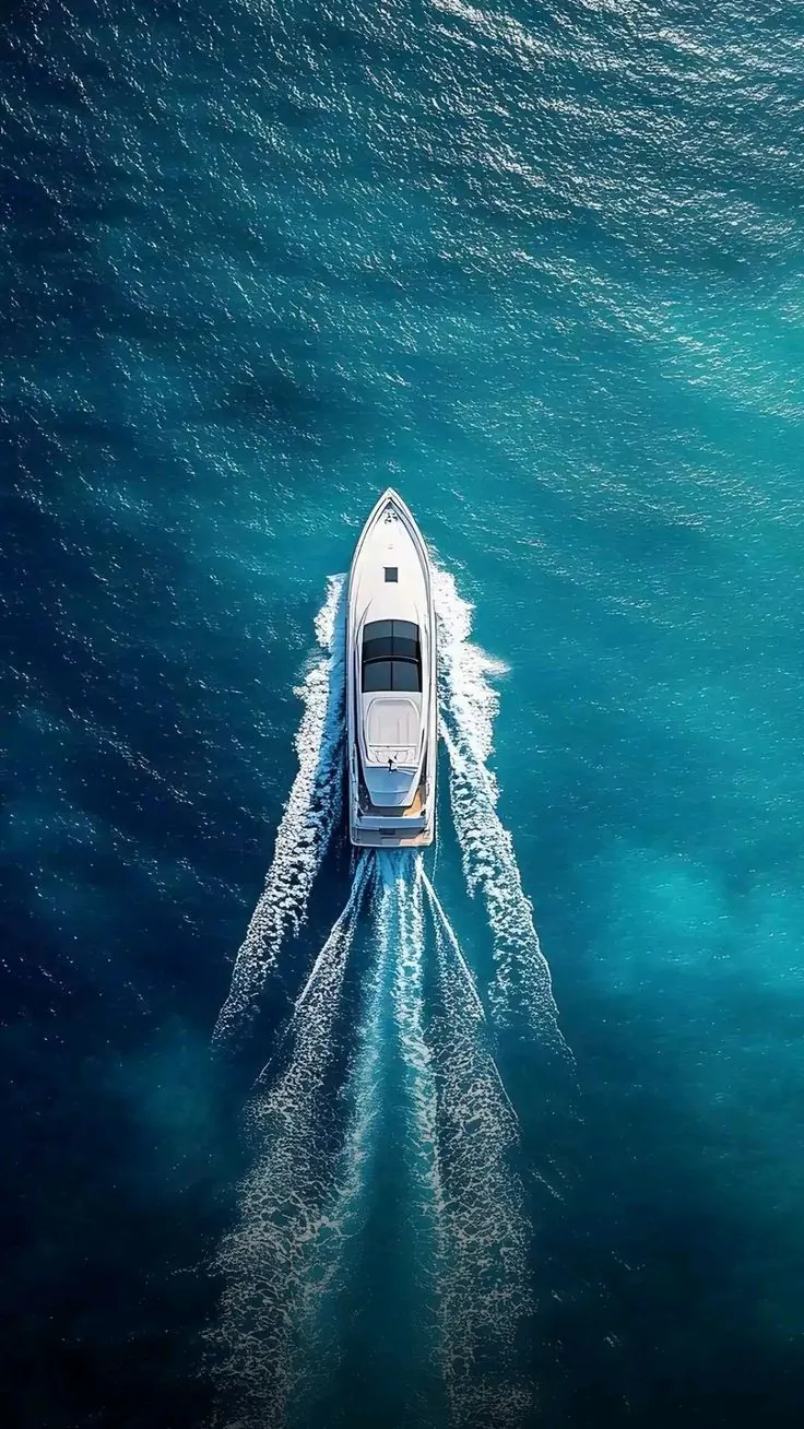 Iate navegando em mar azul, visto de cima